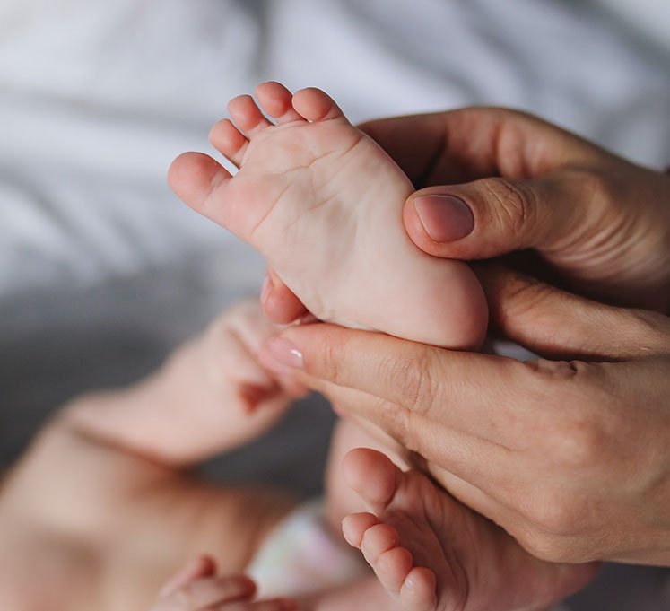 Newborn baby's feet held in a parent's hands